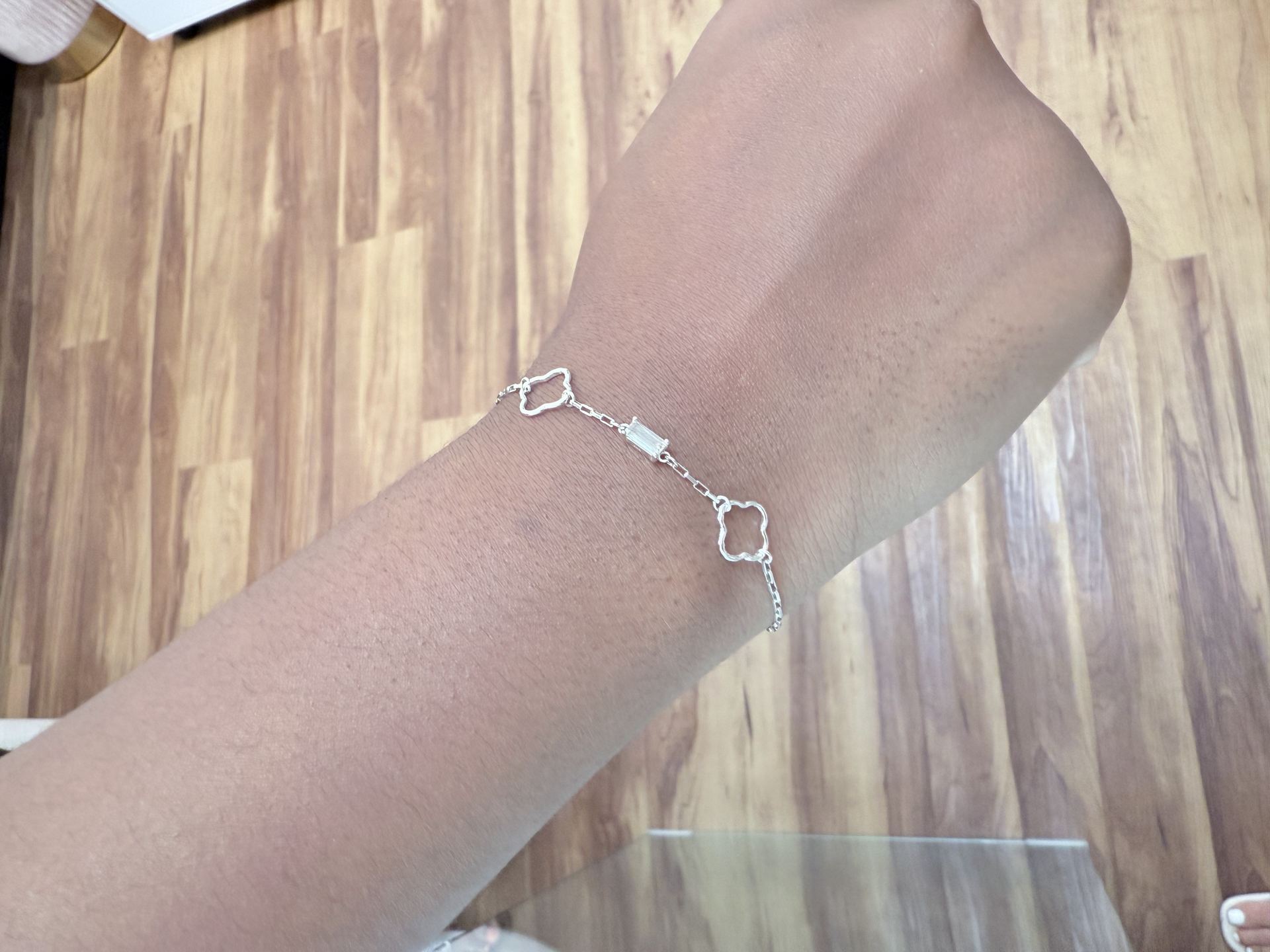 Silver bracelet with irregular open flower-shaped links and a single baguette gemstone bar